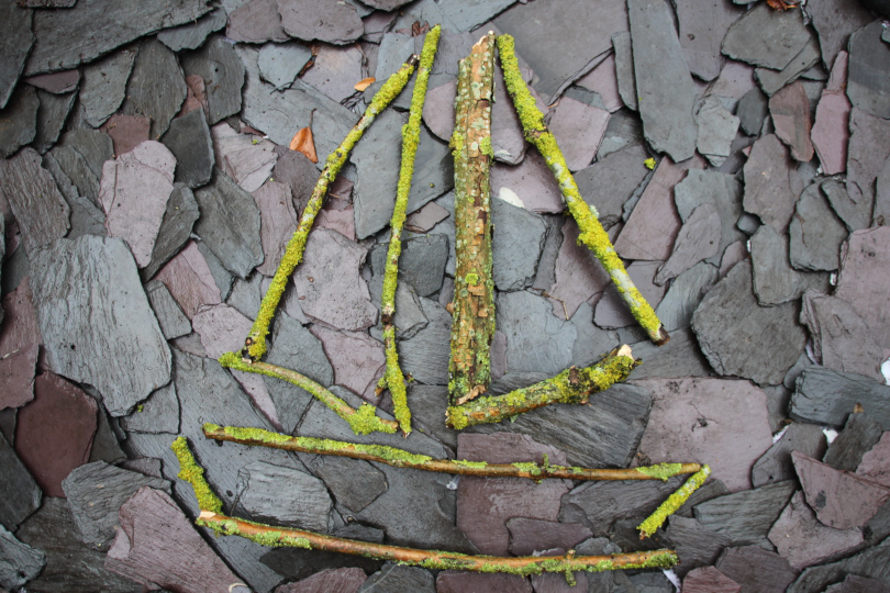 sticks of different lengths and thicknesses making a picture of a boat 