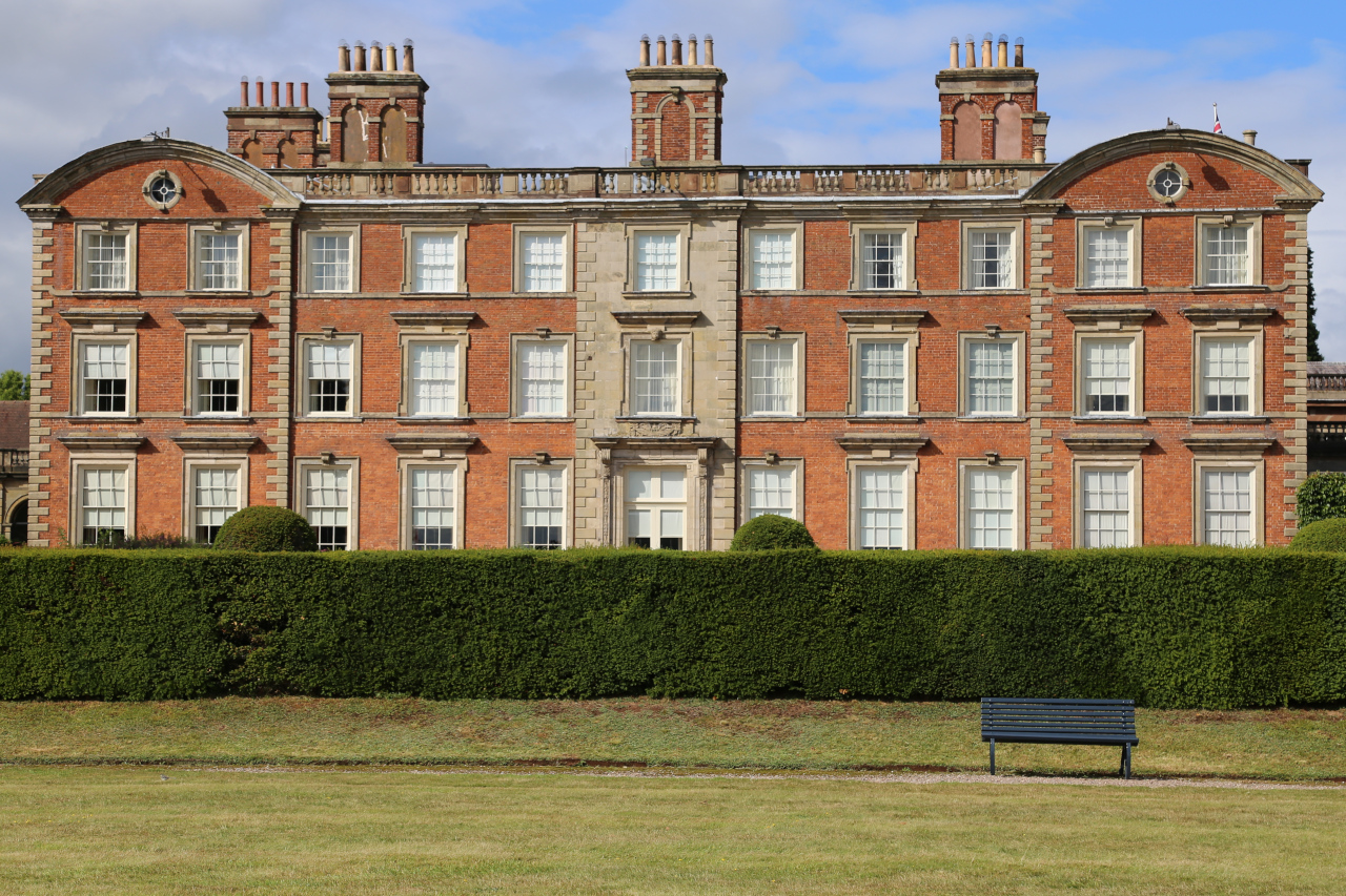 a grand building with three rows of eleven windows and three sets of five chimney pots